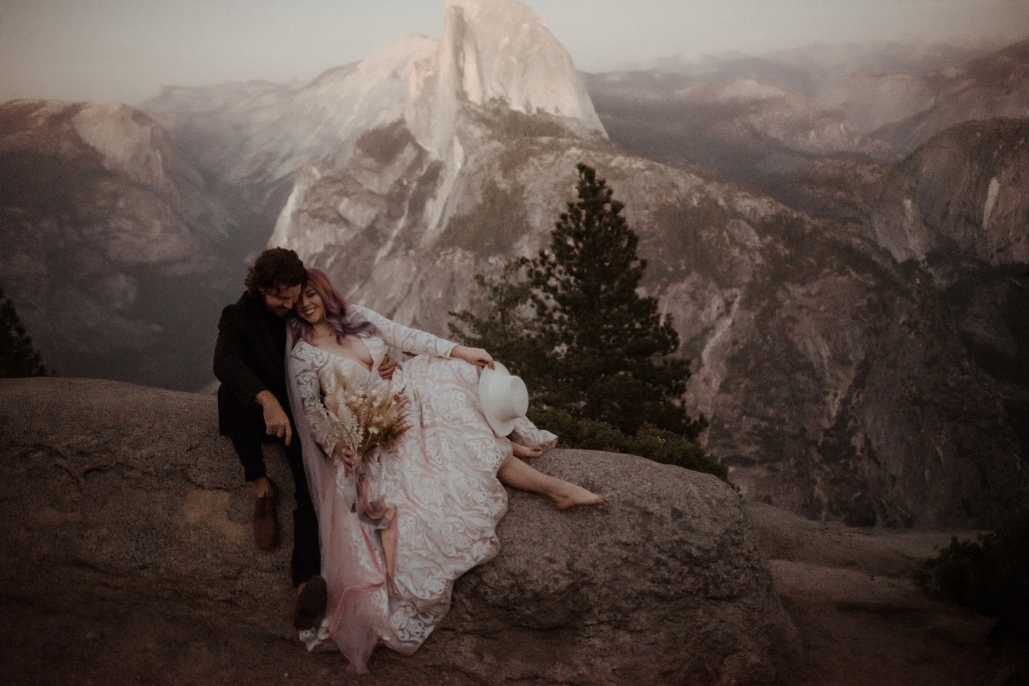 https://content1.getnarrativeapp.com/static/034e72ee-5809-4930-a3c2-8daa4d7e5fd5/bride-with-purple-hair-in-hat-and-pink-veil-eloping-at-Yosemite-National-Park.jpg?w=1500