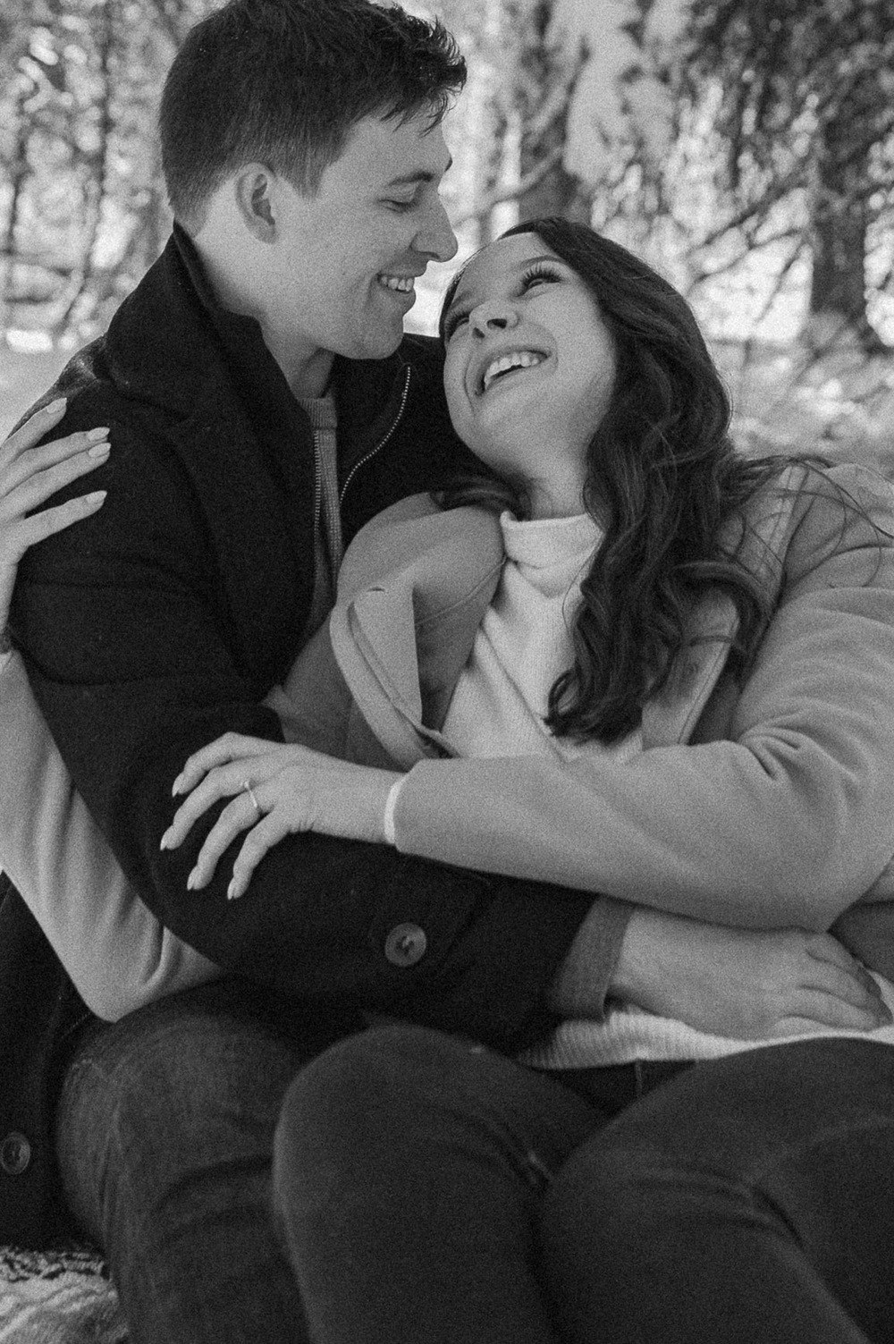 black and white shot of couple cuddling during a winter picnic for an engagement session in the Rocky Mountains of Alberta