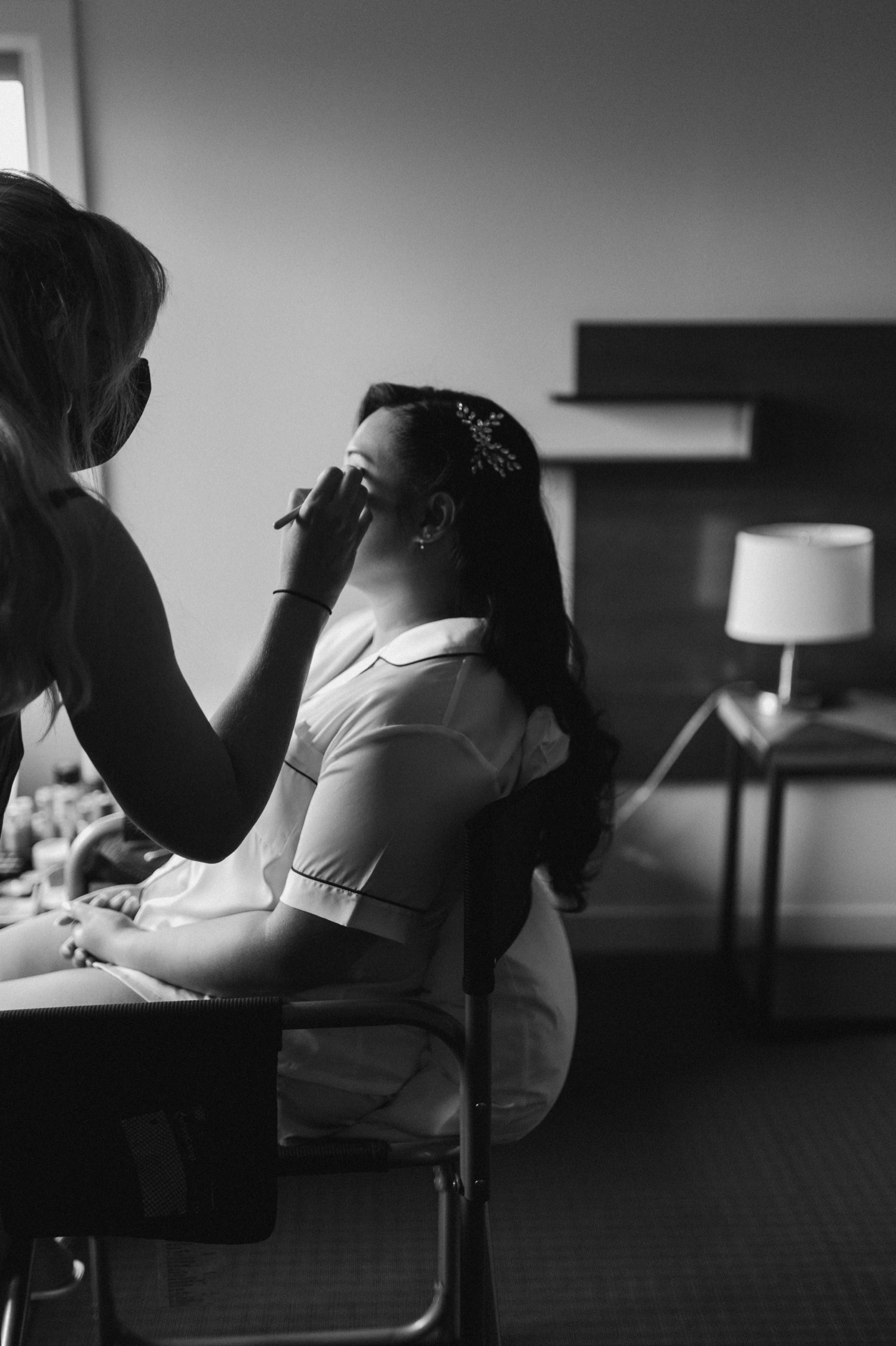 black and white shot of bride getting hair and make up done for a mountain elopement during wildfire season in Banff Alberta