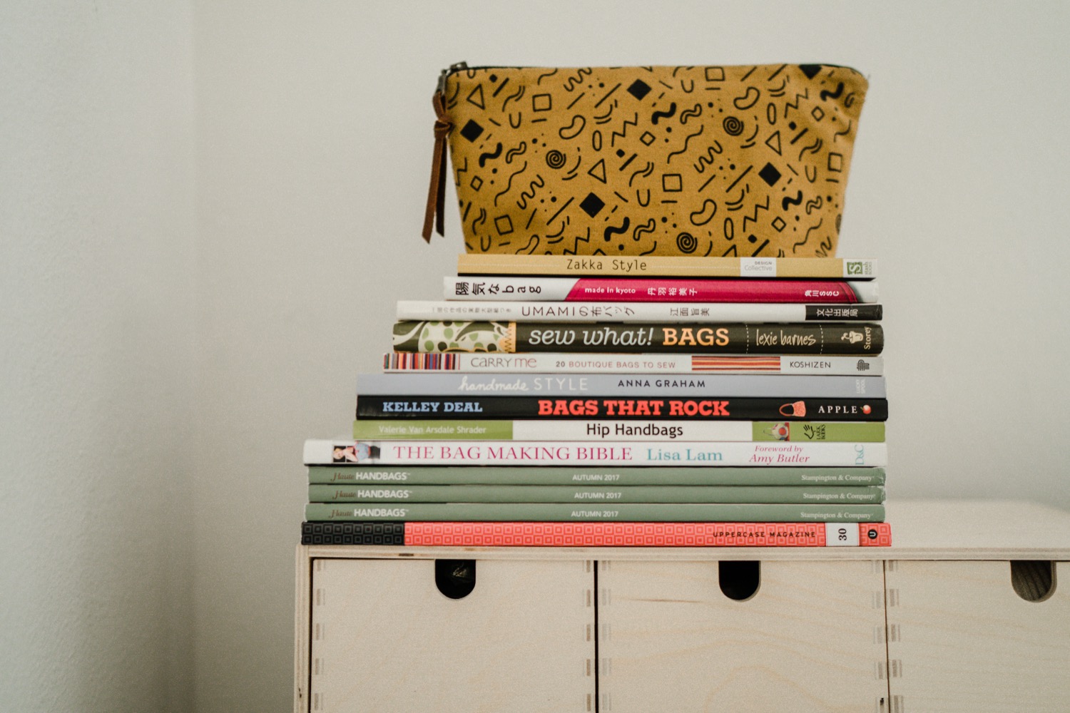 Yellow geometrical print bag sitting on a stack of books