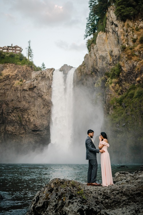 Couple standing on rock in front of Snoqualmie Falls