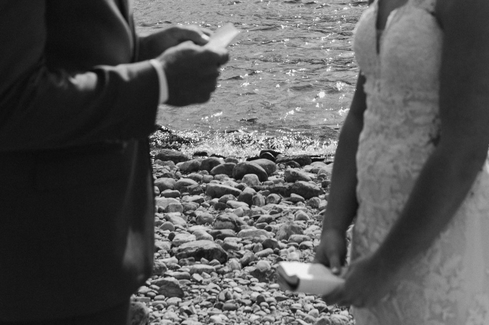 The bride and groom reading their vows at their Elopement ceremony on the shore of Spray Lakes in Kananaskis Alberta
