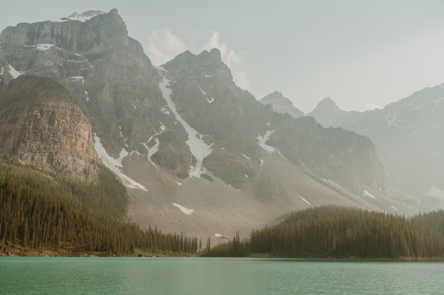 landscape shot of view of mountains surrounding Moraine Lake in Alberta Canada