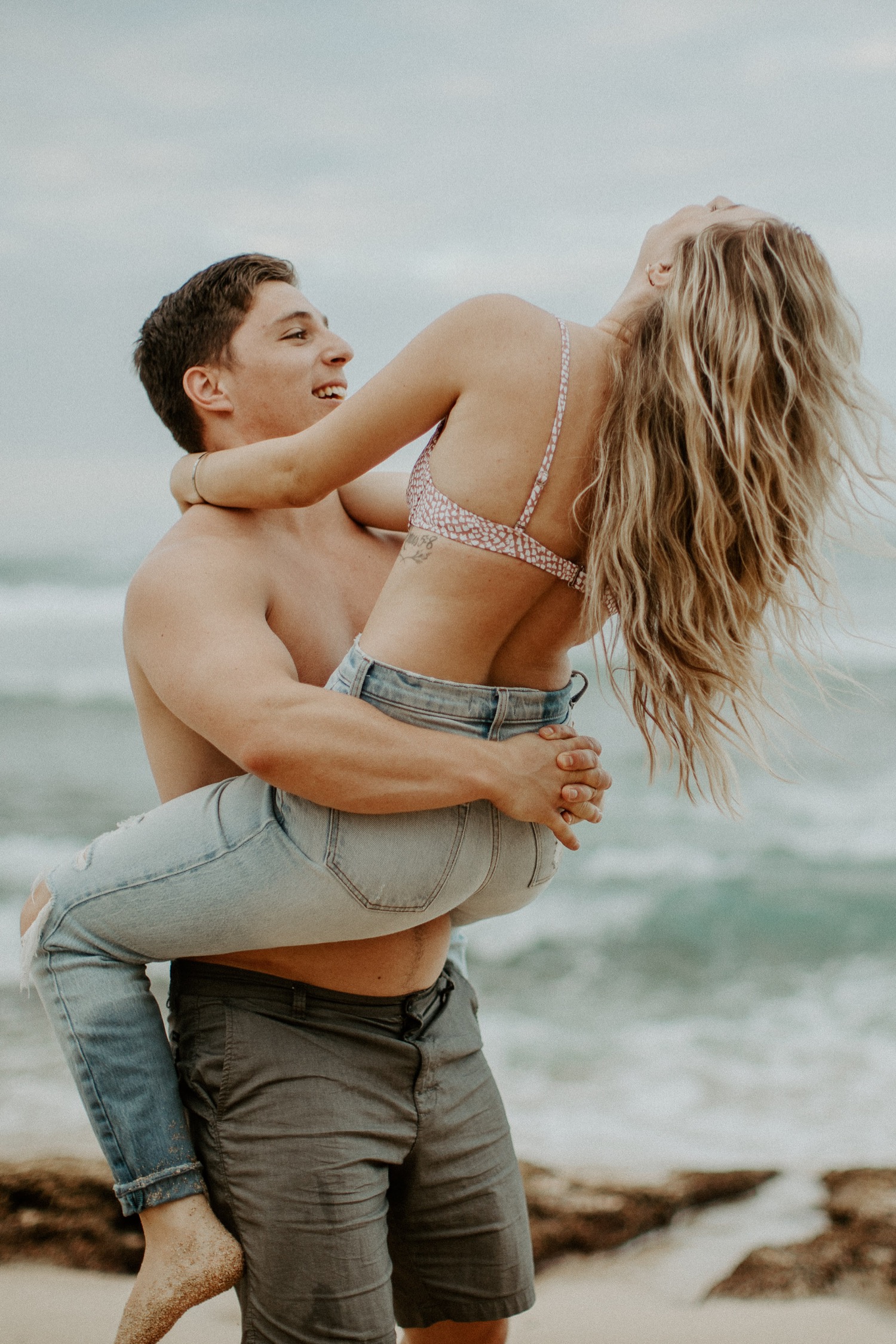 A Playful Couple Posing on the Beach · Free Stock Photo