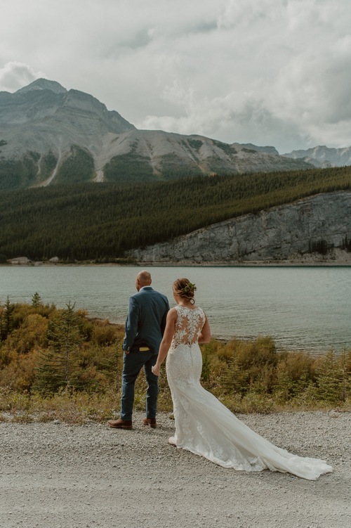 The bride and groom doing their first look overlooking their ceremony location in Kananaskis Alberta