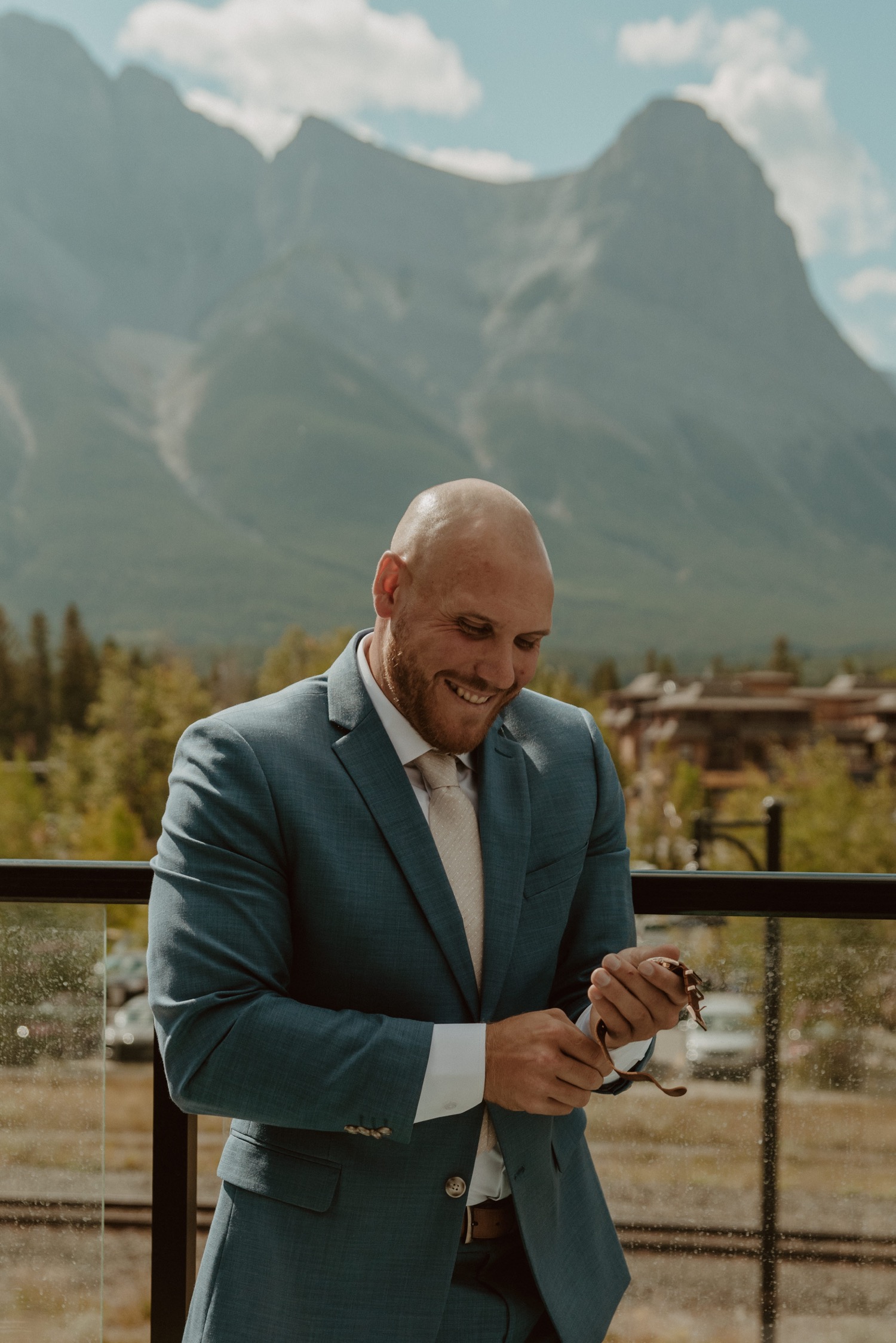 The groom relaxing and getting ready for his elopement at their mountain airbnb in Canmore AB