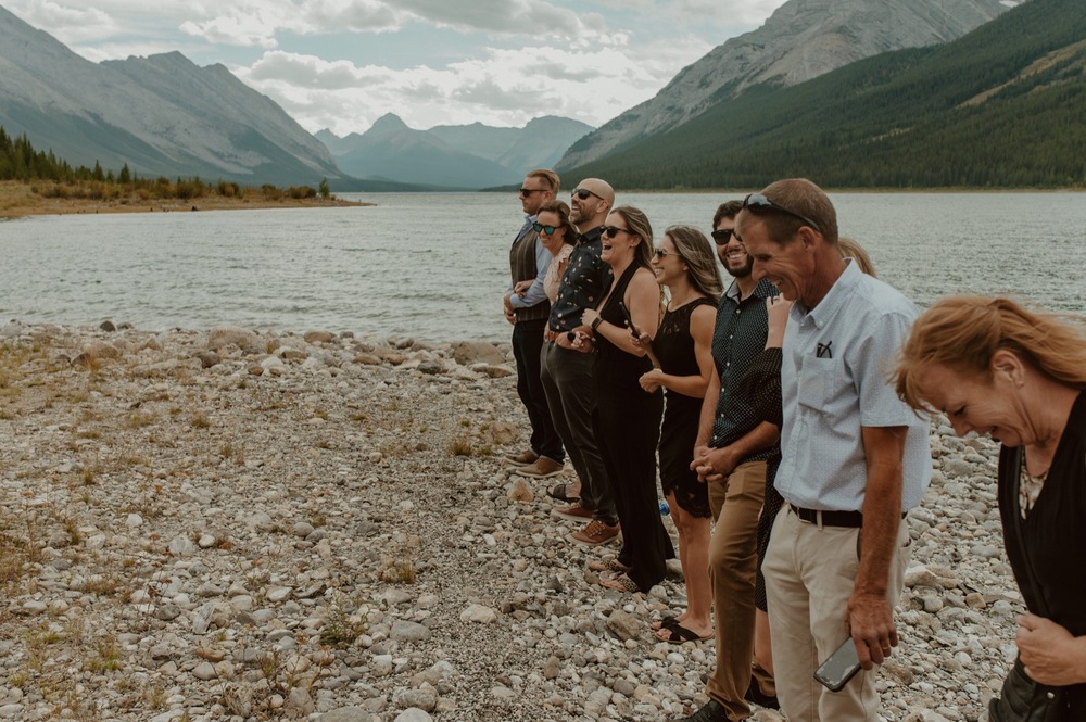 Family and friends gather on the shore of Spray Lakes in Kananaskis Alberta for the bride and grooms elopement