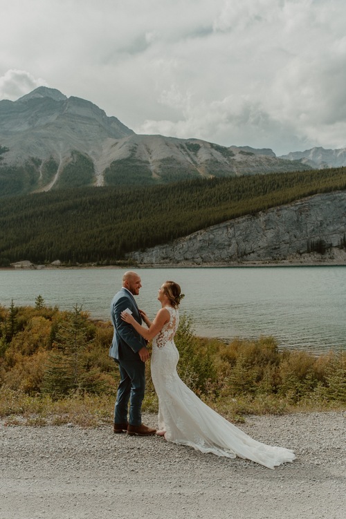 The bride and groom doing their first look overlooking their ceremony location in Kananaskis Alberta
