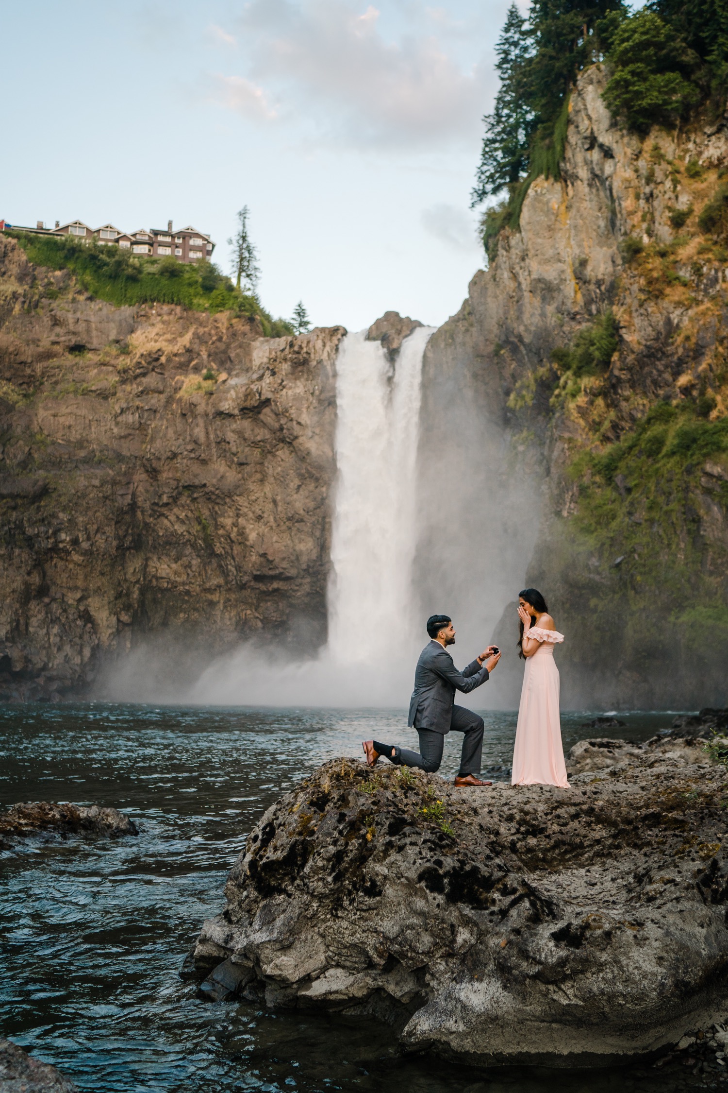 Man proposes to woman with Snoqualmie Falls in the background during surprise proposal session