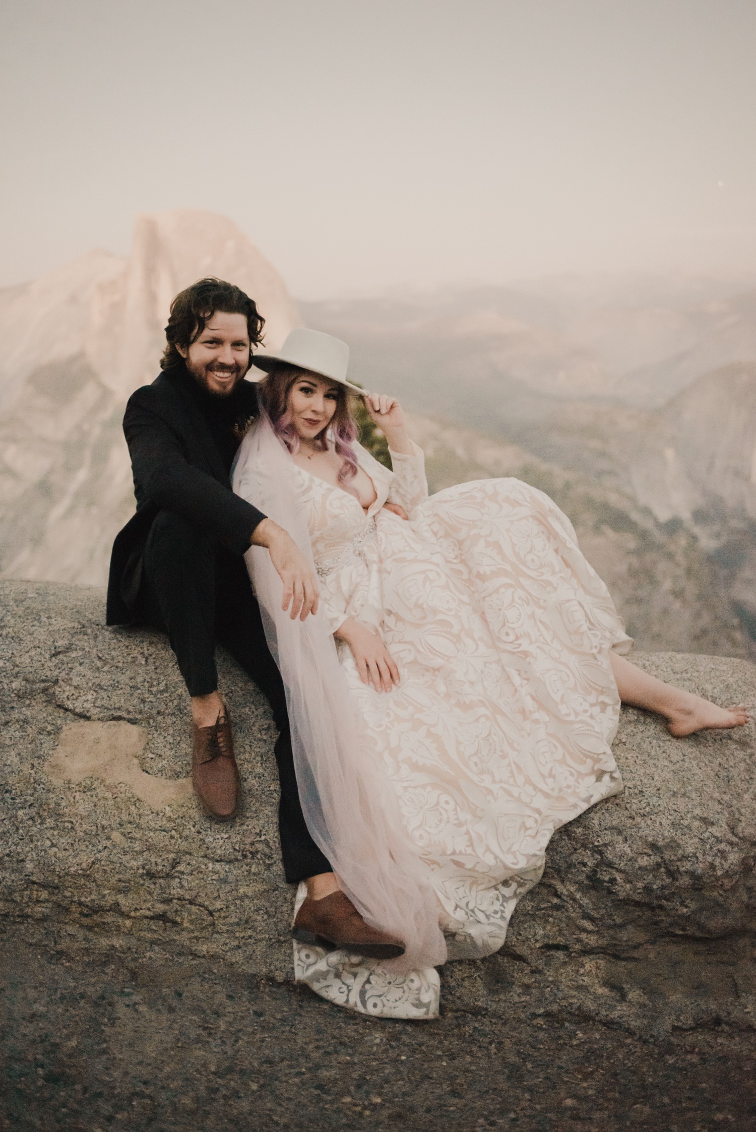 https://content1.getnarrativeapp.com/static/48e8bb68-8622-46cd-96d6-dfb3f5e302ac/bride-with-purple-hair-in-hat-and-pink-veil-eloping-at-Yosemite-National-Park.jpg?w=1500