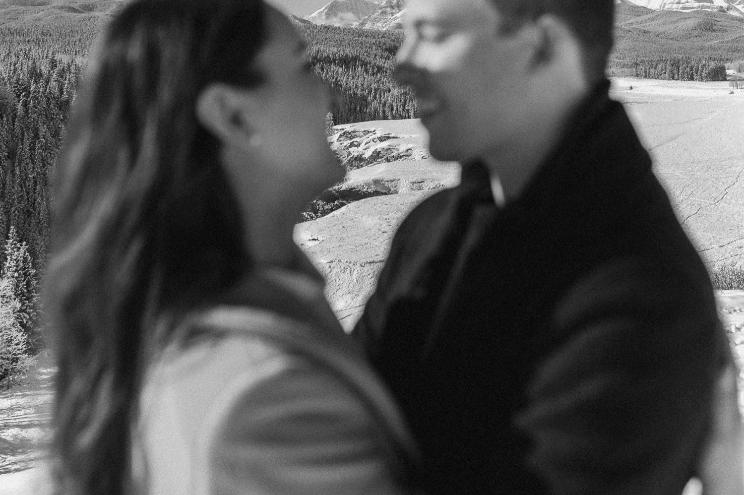 black and white out of focus shot of couple during a winter engagement session in the rocky mountains of Alberta