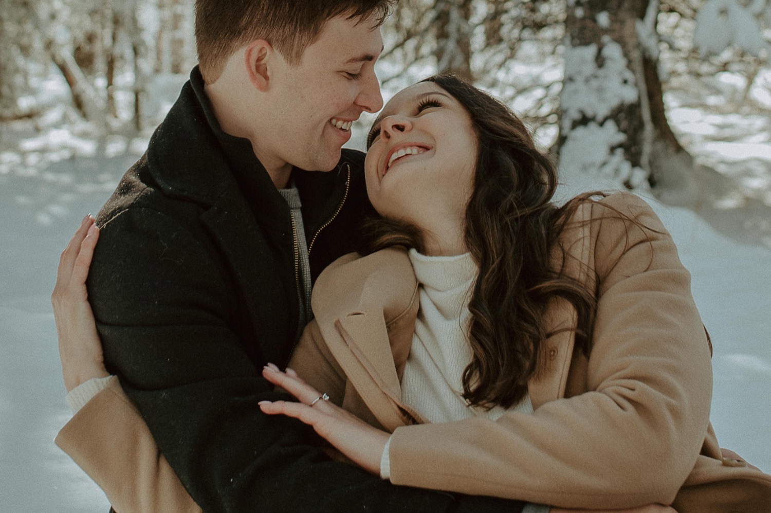 couple cuddling during a winter picnic for an engagement session in the Rocky Mountains of Alberta