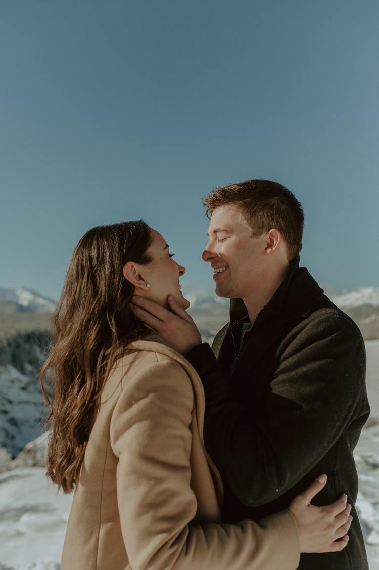 couple holding each other during a winter engagement session in the rocky mountains of Alberta
