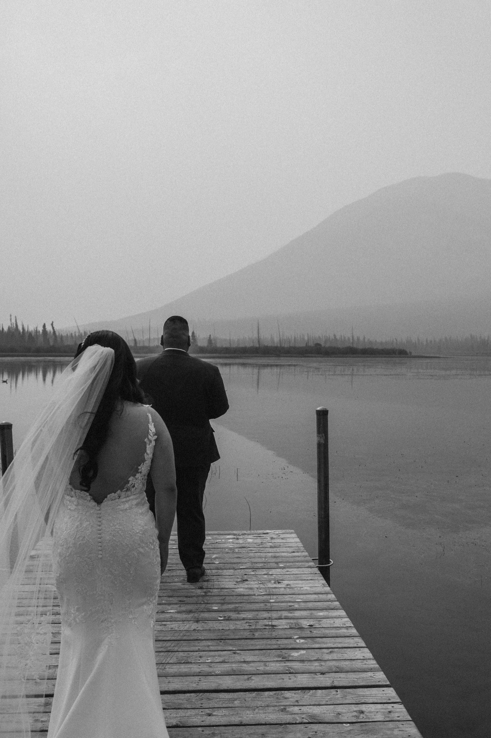 black and white shot of bride behind groom before their first look for a mountain elopement during wildfire season in Banff Alberta