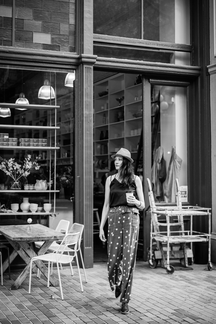 Woman walking out of coffee shop and looking in the distance during Pioneer Square portraits.