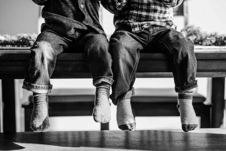 Legs and feet of little boys sitting on kitchen table