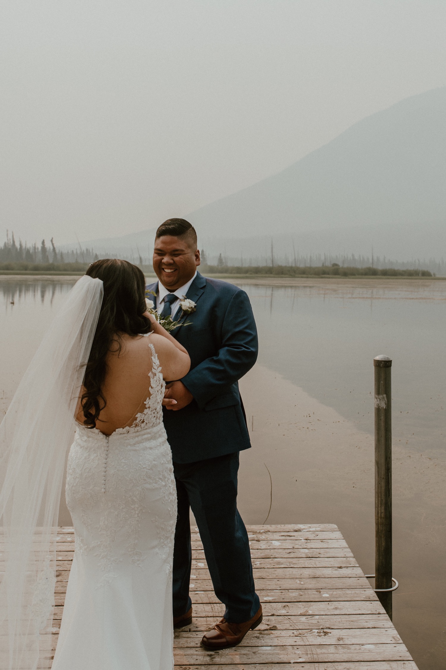 grooms reaction to bride during first look for a mountain elopement during wildfire season in Banff Alberta