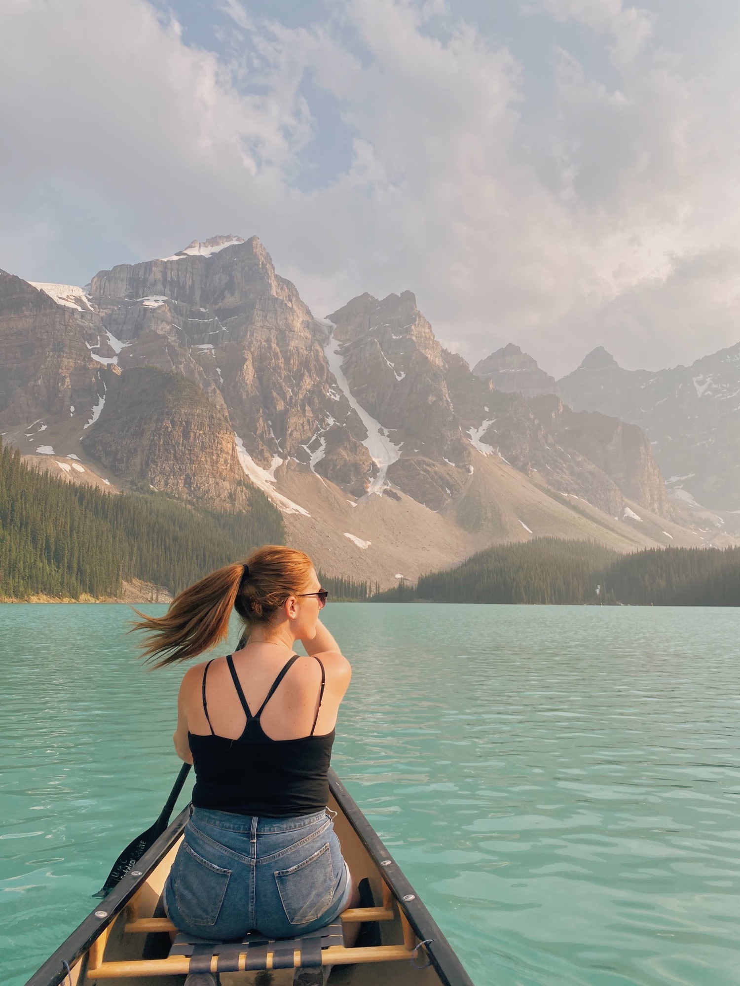 girl canoeing on Moraine Lake during the summer in Banff National Park Canada