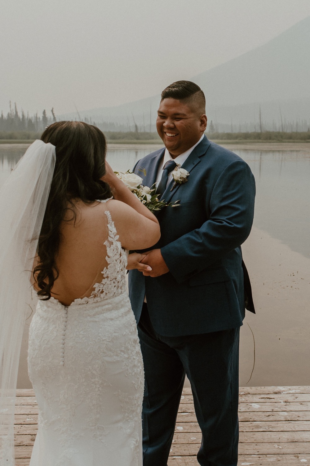 grooms reaction to bride during first look for a mountain elopement during wildfire season in Banff Alberta