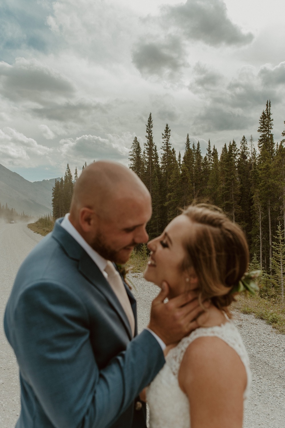 The bride and groom taking in each other moments before their ceremony on a dirt mountain road in Kananaskis Alberta
