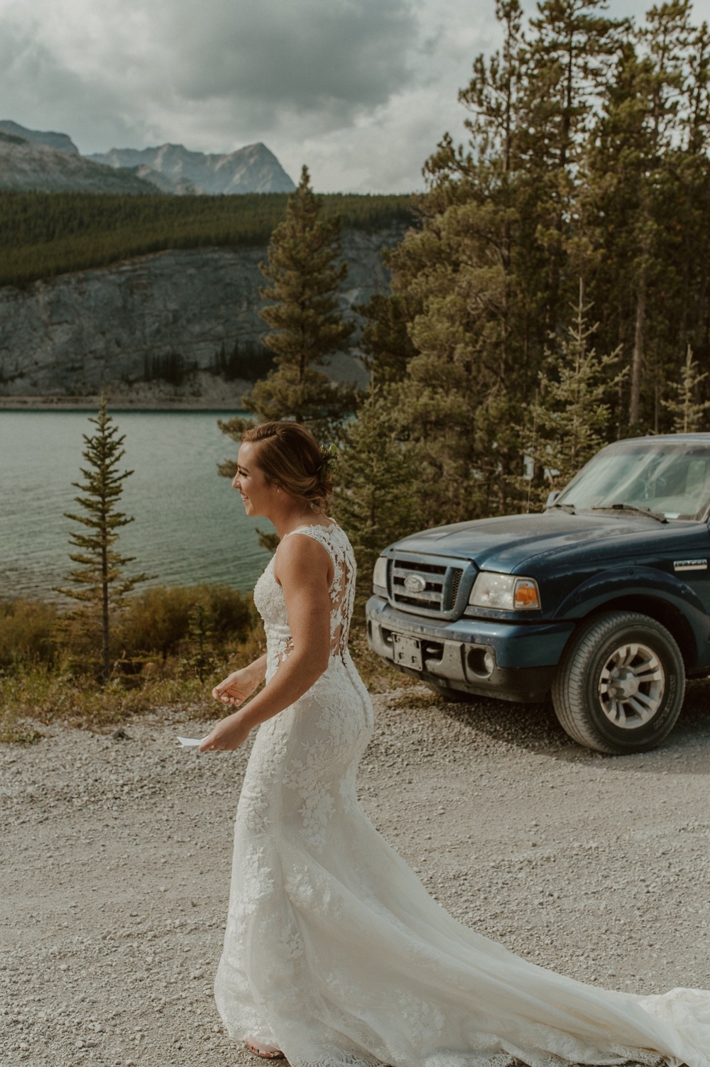 Driving down a dirt mountain road to the location of their elopement ceremony in Kananaskis Alberta