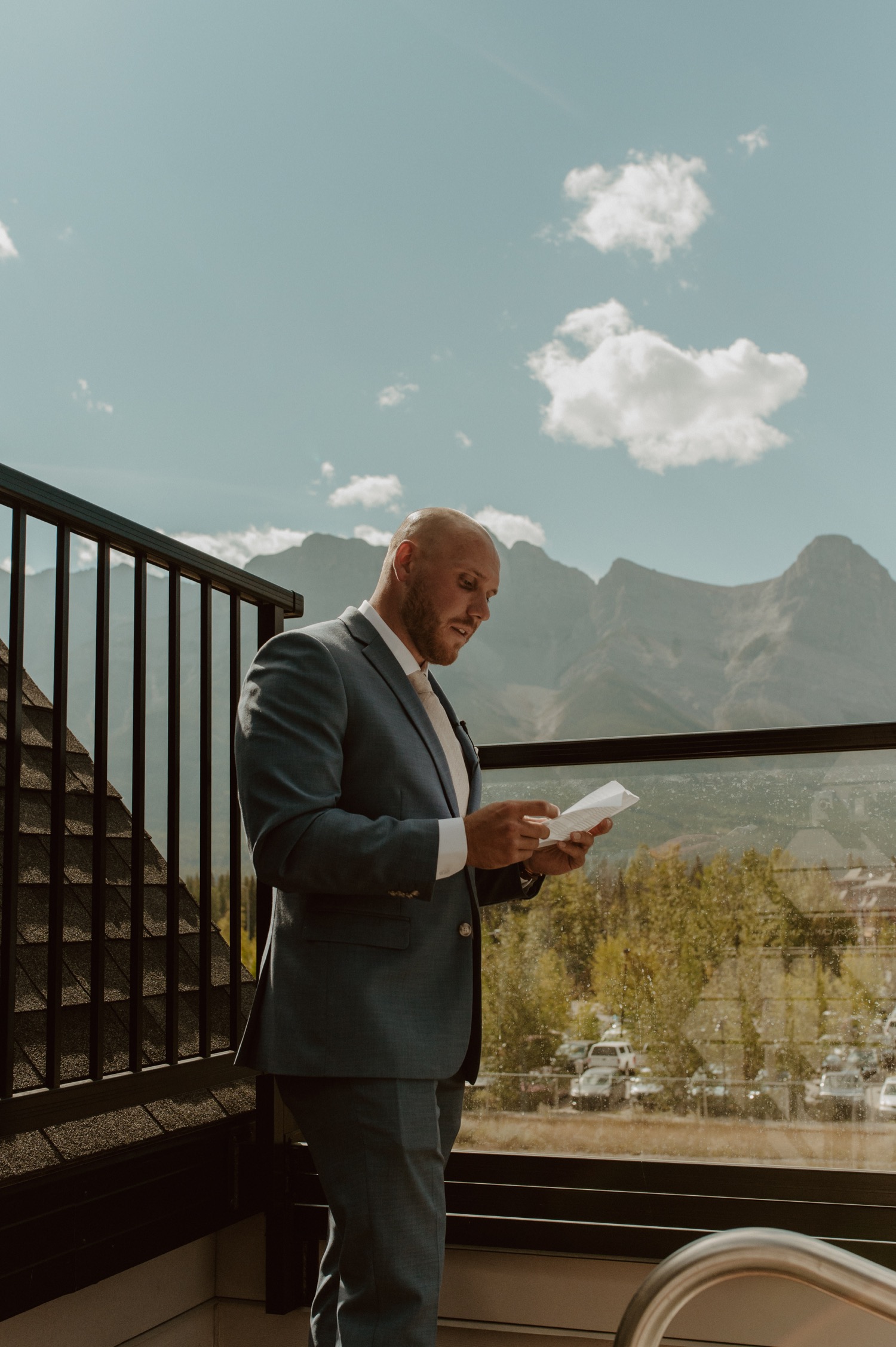 The groom going over his vows for his elopement at their mountain airbnb in Canmore AB