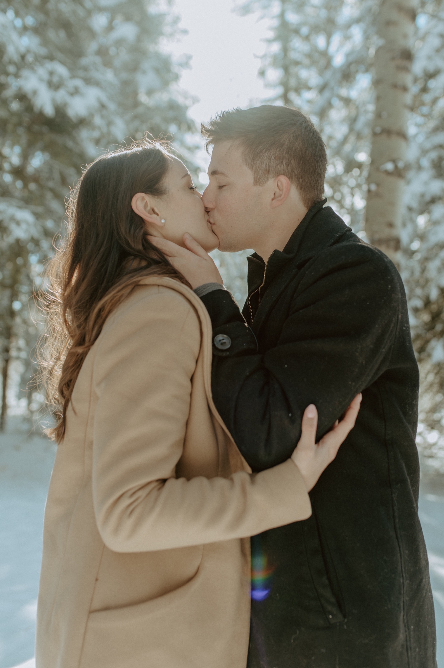 couple kissing during a winter engagement session in Kananaskis Alberta