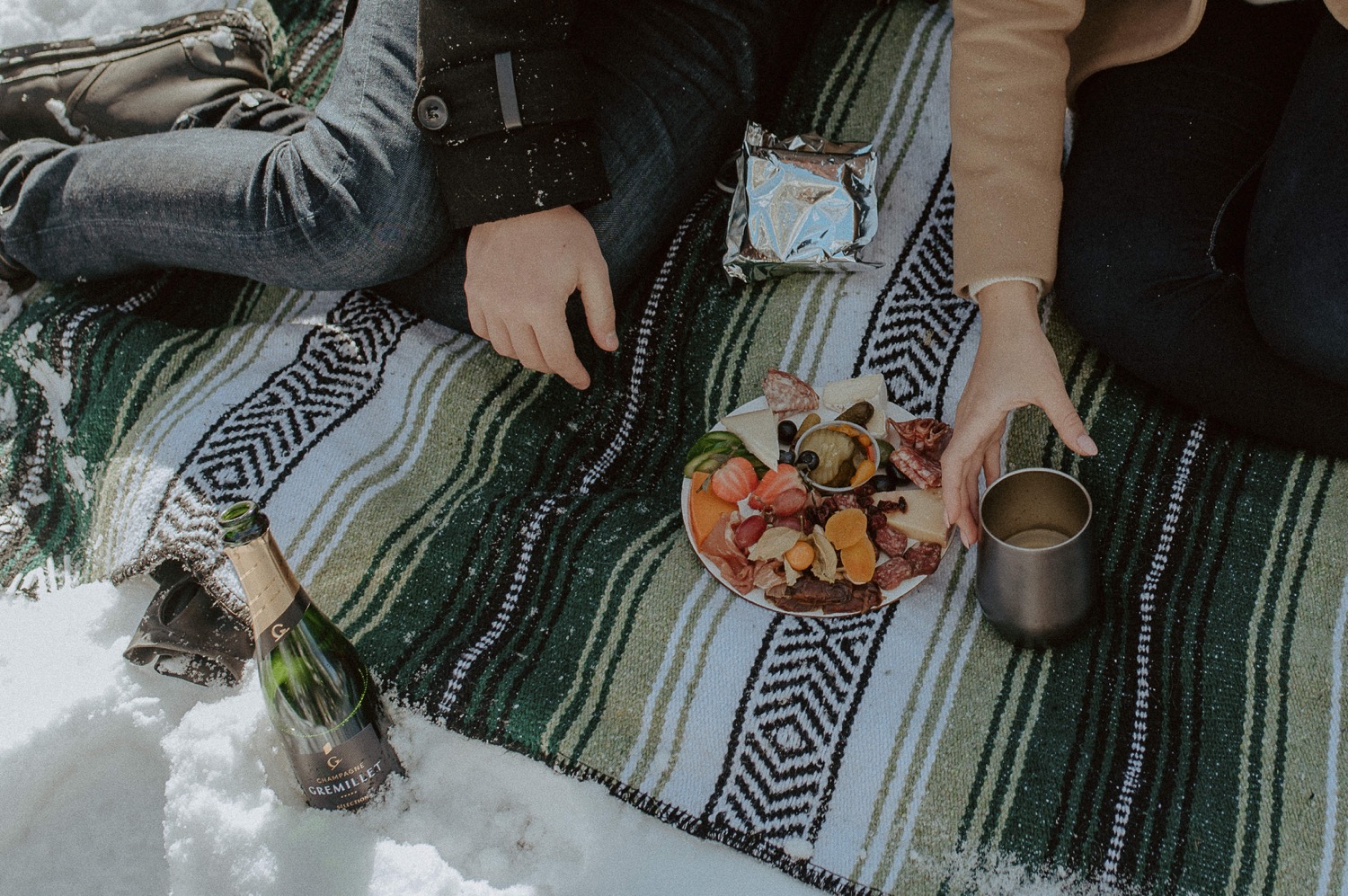 detail shot of couple enjoying a winter picnic during a winter engagement session in the rocky mountains of Alberta