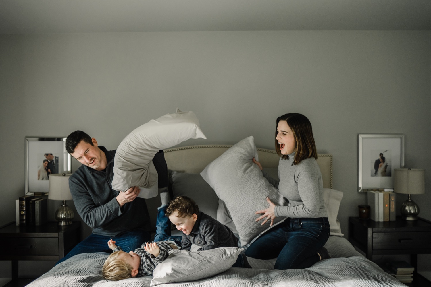 Family playing pillow fight in bedroom