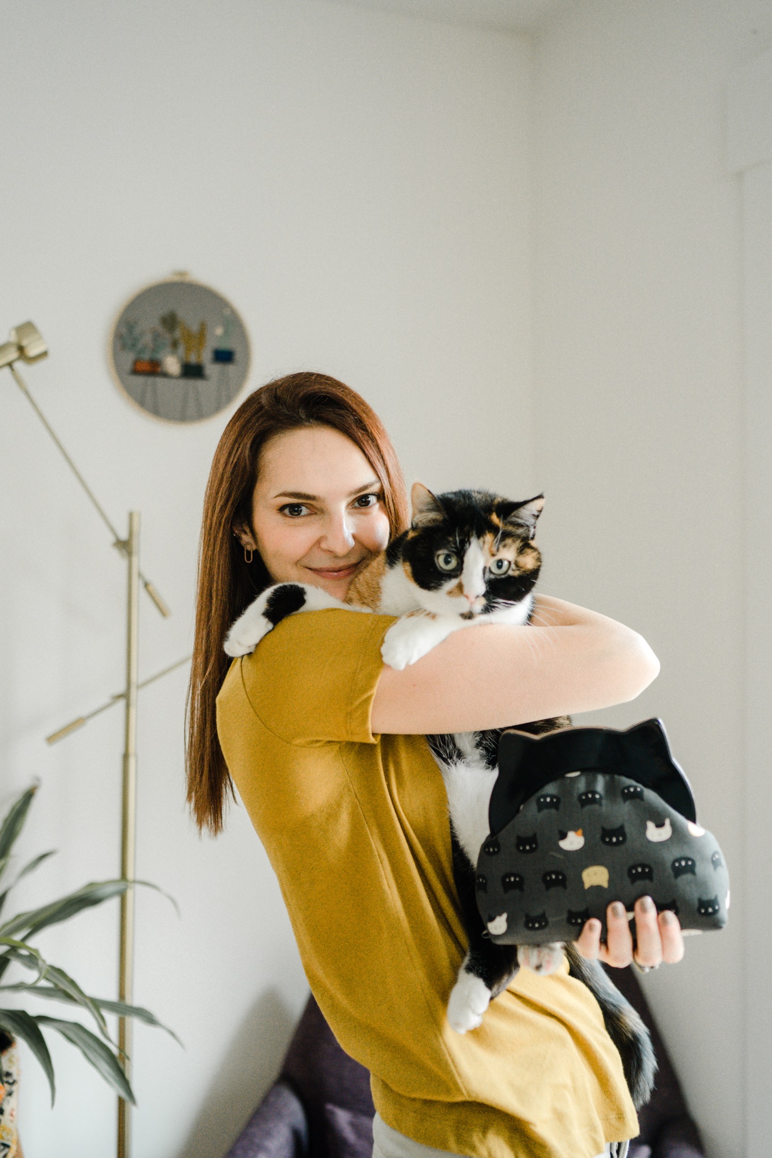 Woman holding her cat and a handmade cat print bag for studio portraits
