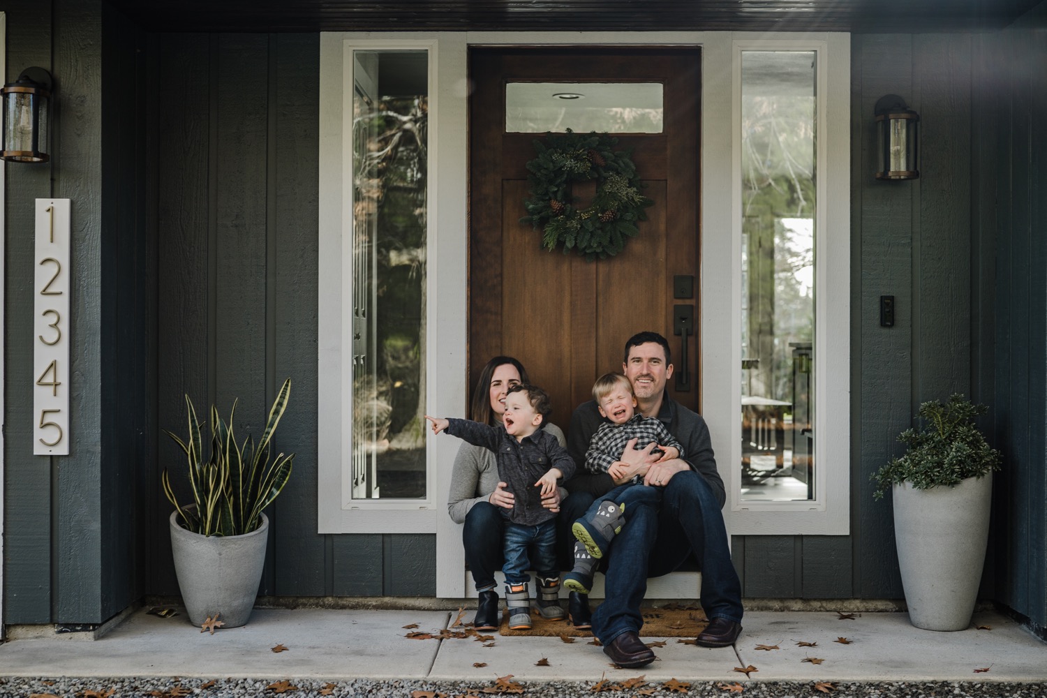 Family of 4 sitting on their front porch for a photo during in-home family session