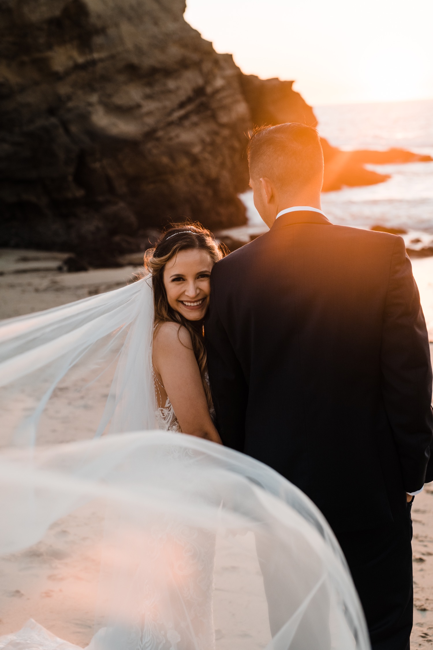 https://content1.getnarrativeapp.com/static/f37f7ea7-587a-4249-af51-ee3f58556aba/Bride-and-groom-sunset-shots-with-veil-at-the-beach-.jpg?w=1500