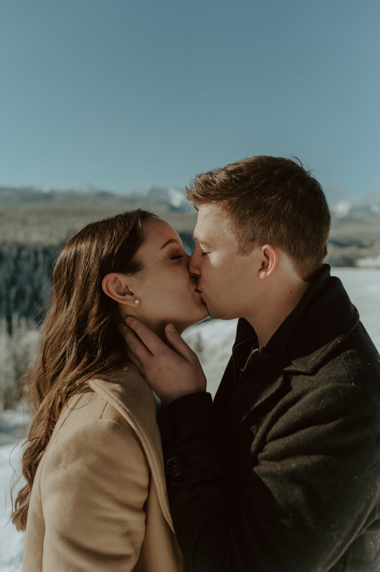 close up shot of couple in front of amazing mountain backdrop during a winter engagement session in the rocky mountains of Alberta