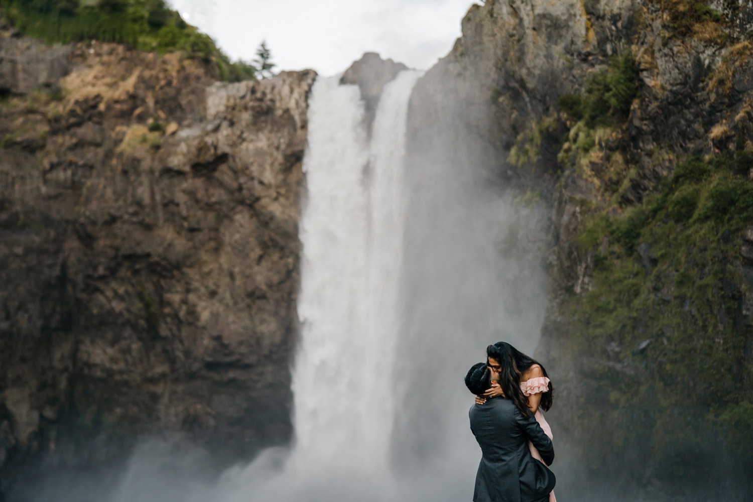 Couple kisses in front of Snoqualmie Falls